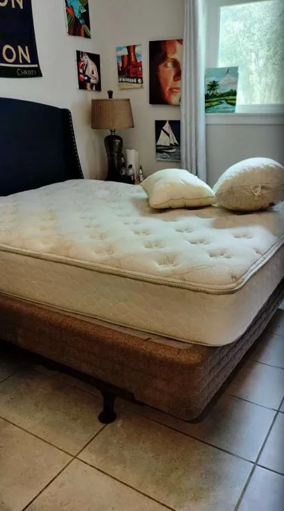 A bedroom with a bare mattress and loose pillows