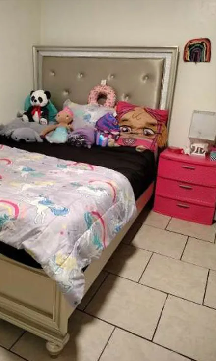 The same bed made, with the toys lined up against the headboard