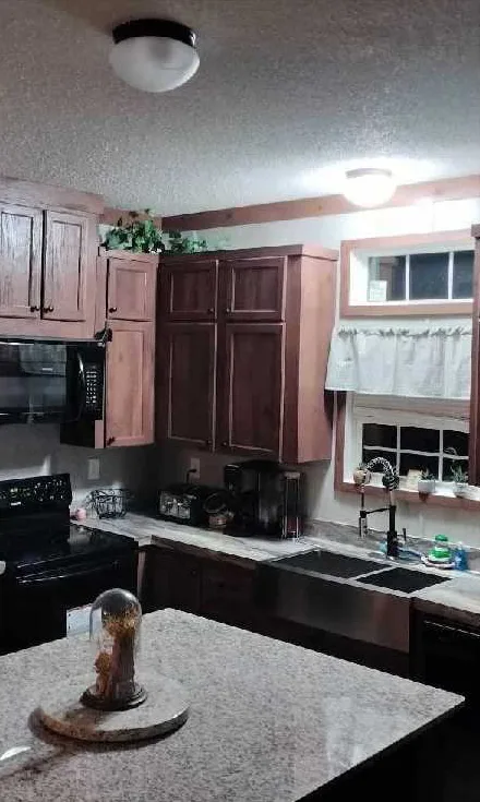 The same kitchen with the counters and island cleared and wiped down